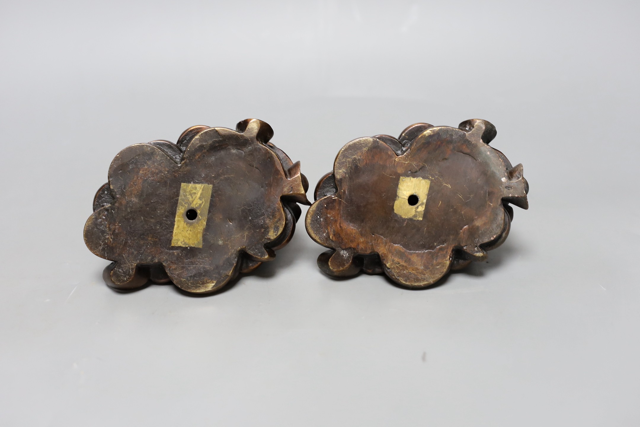Two Chinese bronze models of dragon turtles on a pile of cash, 10cm